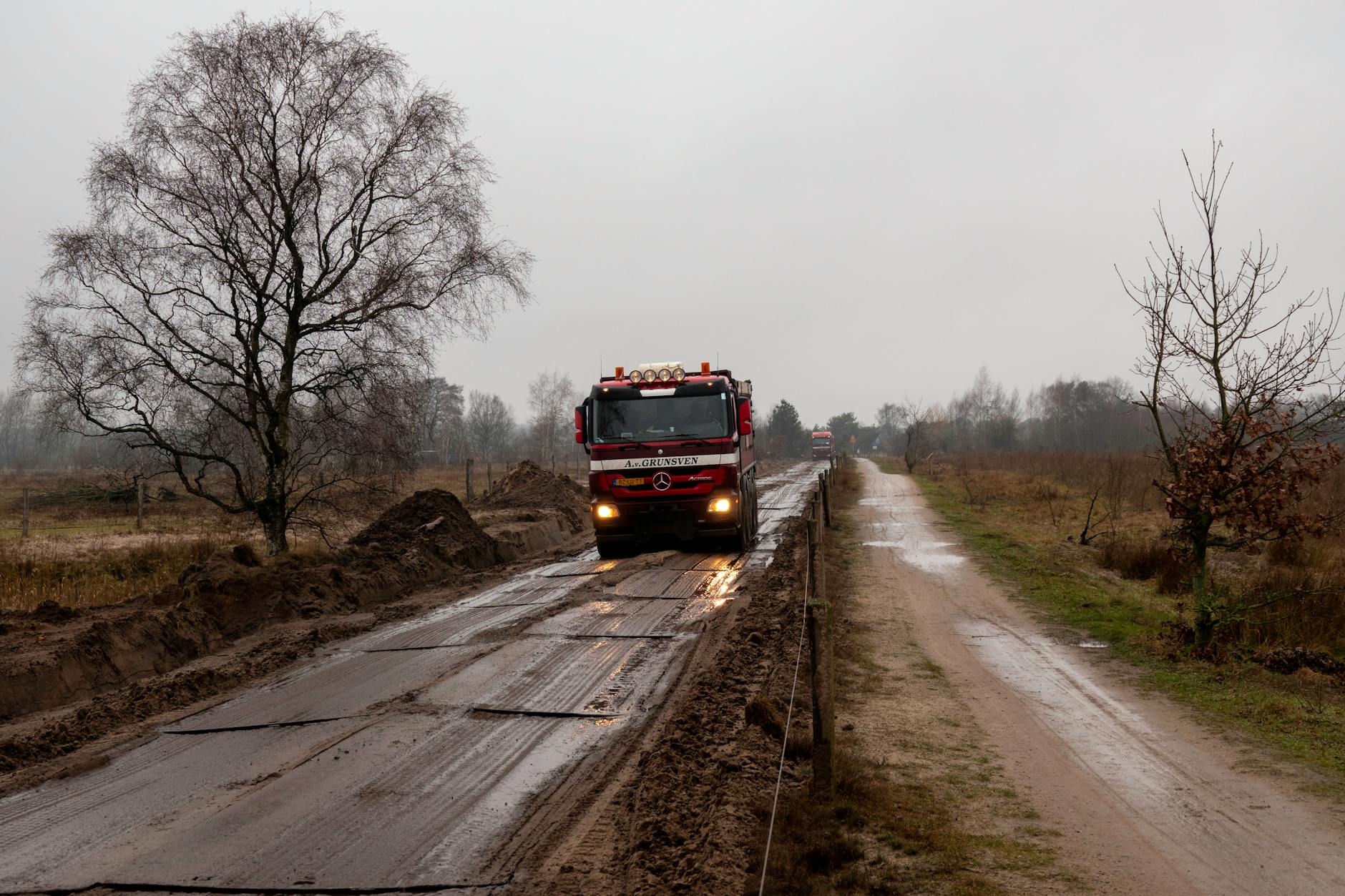 Czerwona ciężarówka na błotnistej wiejskiej drodze w Holandii