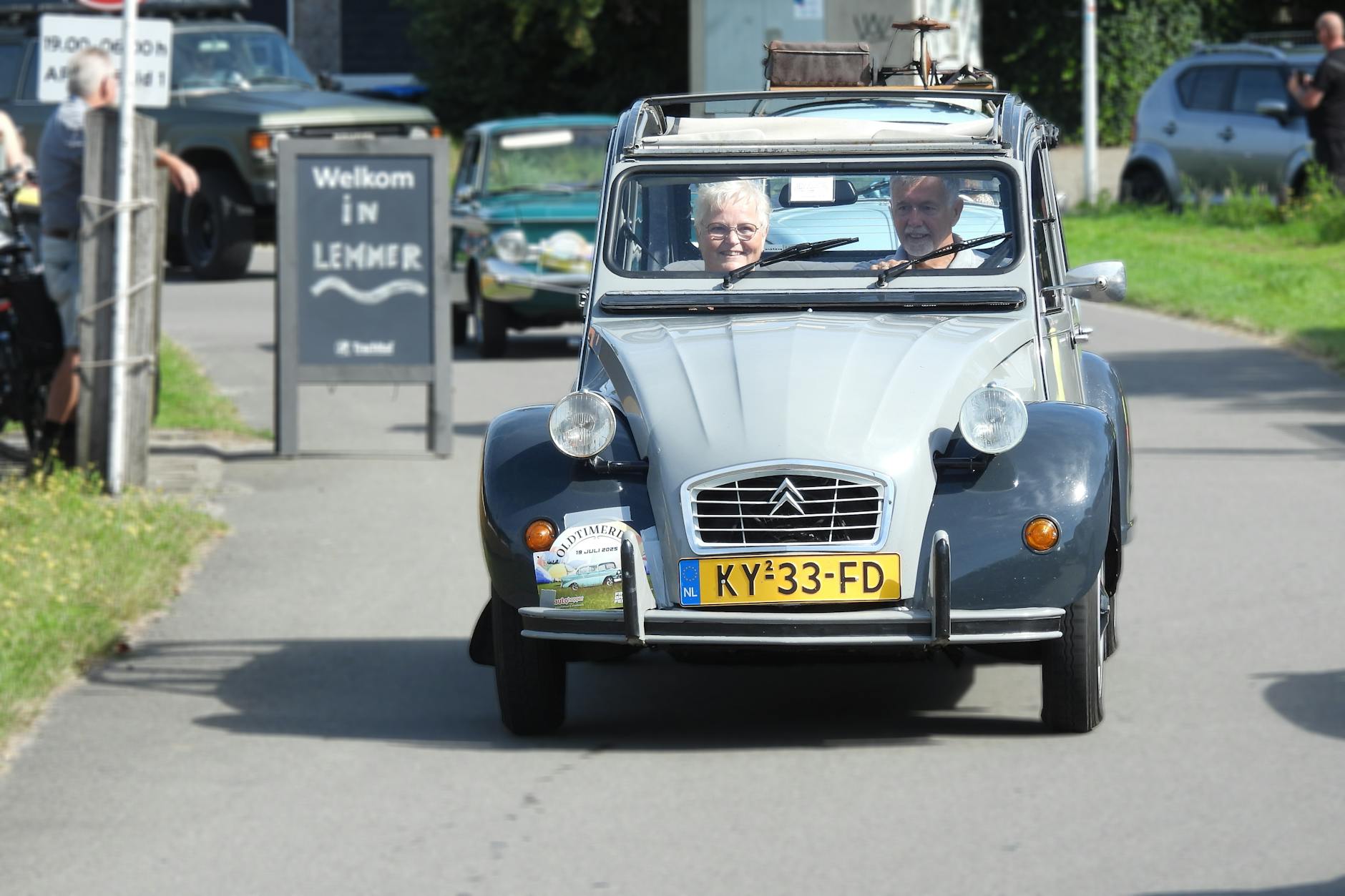 Jak przygotować się do podróży samochodem do Holandii: przepisy, opłaty i parkingi Klasyczny Citroën 2CV z seniorami jedzie ulicą w holenderskim Lemmer