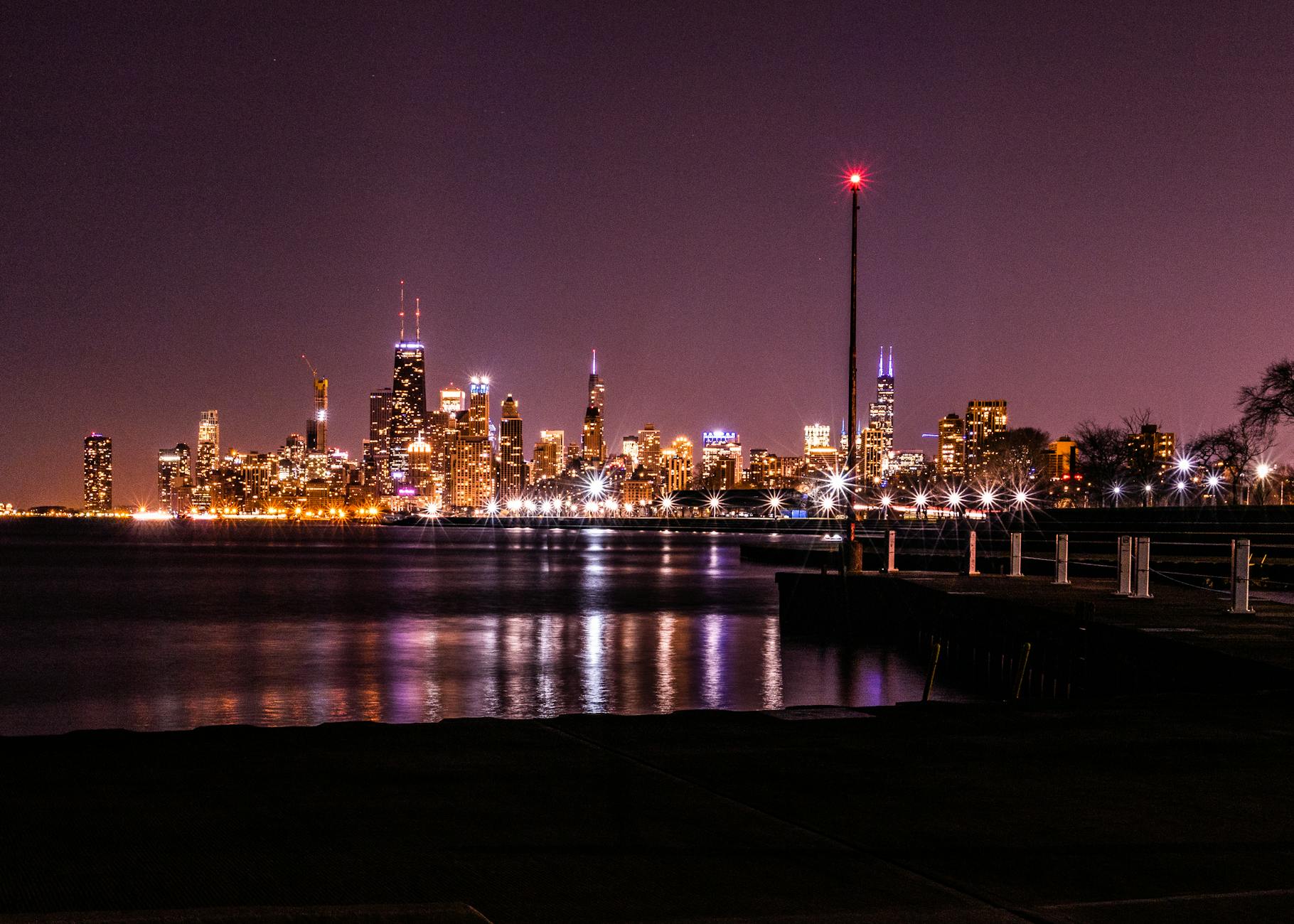 Nocna panorama Chicago z oświetlonymi wieżowcami nad jeziorem Michigan
