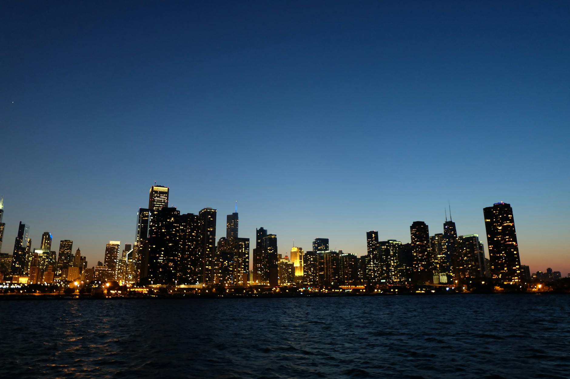 Nocna panorama Chicago z oświetlonymi wieżowcami nad jeziorem Michigan