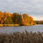 Jesienny krajobraz nad spokojnym jeziorem w Helsinkach, kolorowe drzewa