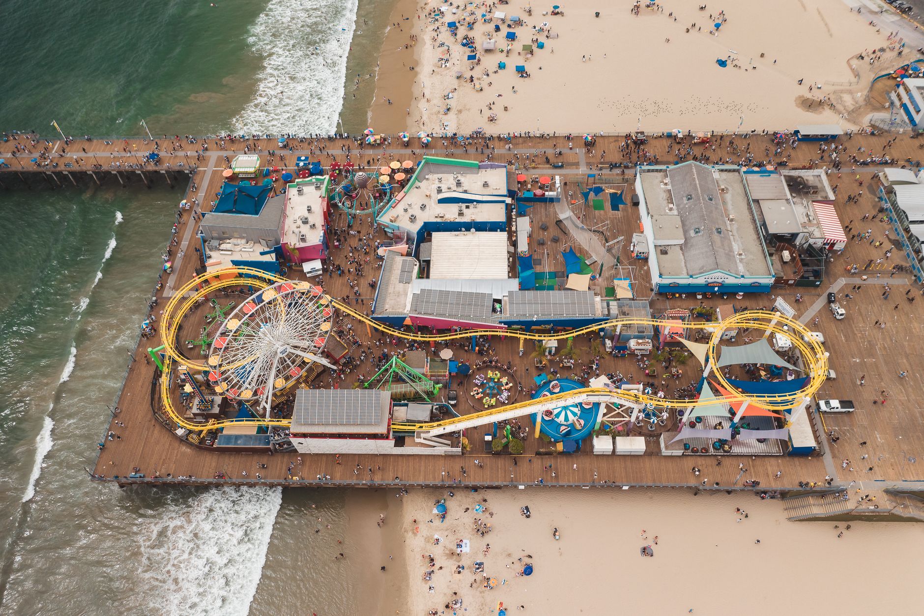 Molo Santa Monica z diabelskim młynem i zatłoczoną plażą z góry