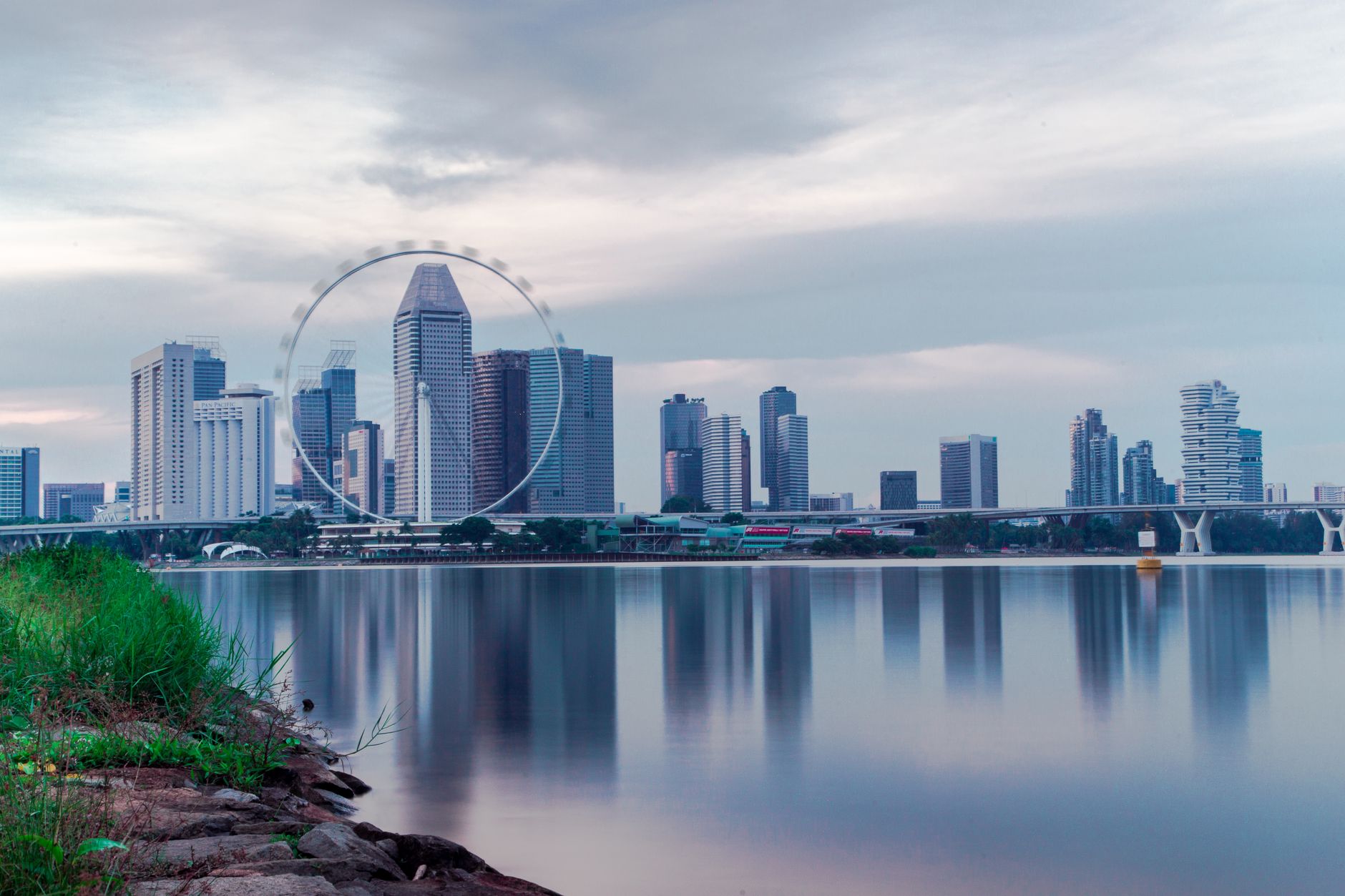 Panorama Singapuru nad wodą z diabelskim młynem Singapore Flyer