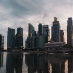 Panorama wieżowców Singapuru odbijających się w wodzie o zmierzchu