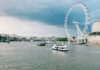 London Eye i Tamiza z łodziami w pochmurny dzień w Londynie