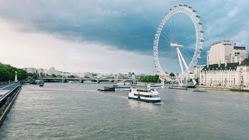 London Eye i Tamiza z łodziami w pochmurny dzień w Londynie