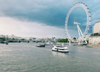 London Eye i Tamiza z łodziami w pochmurny dzień w Londynie